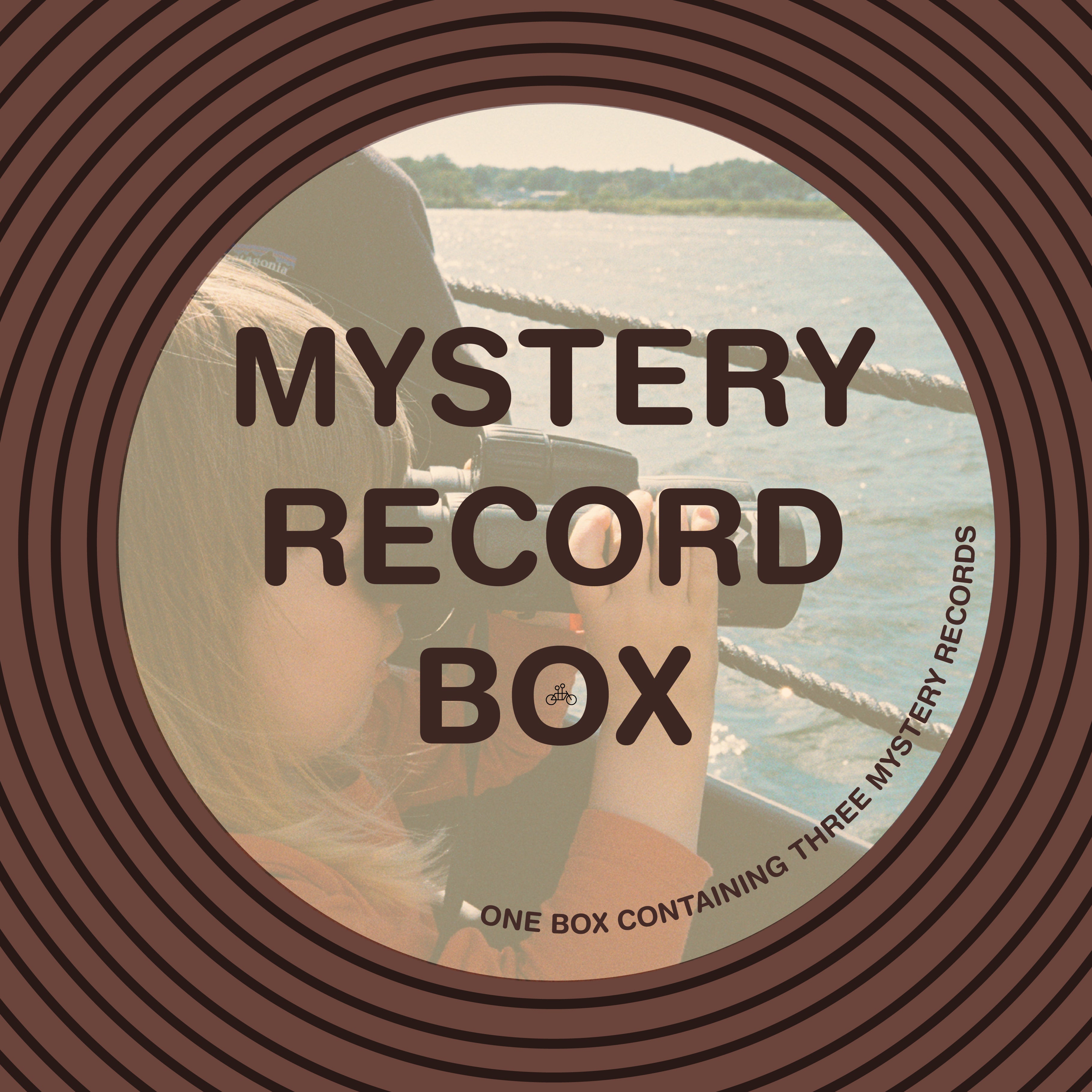 A circular label reads "Mystery Record Box" from Tandem Coffee Roasters over a photo of someone with a camera by the water, bordered by brown circles. Small print below says: One box, three surprise vinyl records—a treat for music lovers.