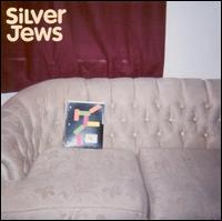 The album cover for "Bright Flight" by Silver Jews features a beige couch set against a wall adorned with a red curtain. On the couch rests an abstract-patterned book or record that adds a burst of color to the scene. The brand name "Tandem Coffee Roasters" is elegantly displayed in white text in the top left corner, hinting at the music and tracklist within.